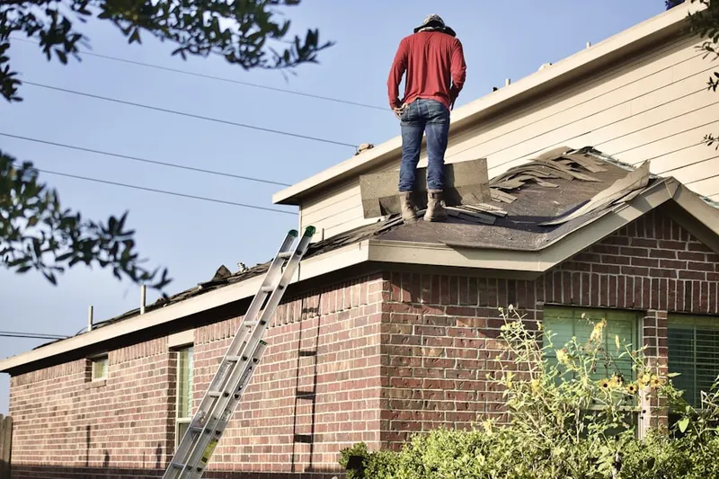 Professional roofer working on a residential roof in West Falmouth